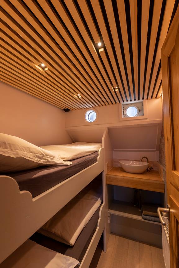 Hut met stapelbed en wastafel op de Avontuur