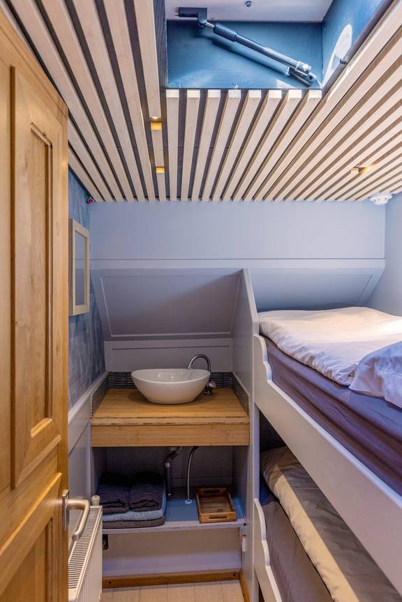 Hut met stapelbed, wastafel en dakluik op de Avontuur