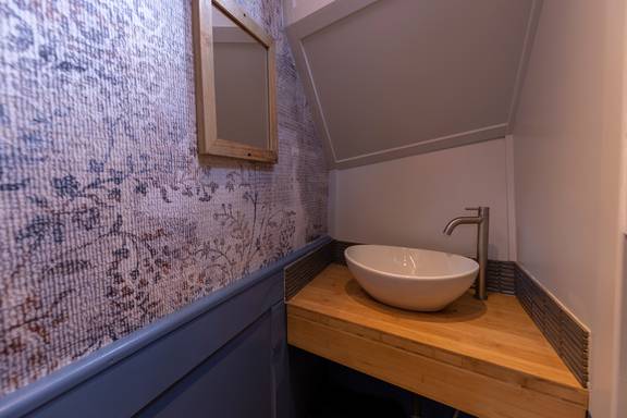 Wastafel met spiegel in een hut van de Avontuur