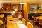 Zithoek met houten tafel en koperen hanglamp in de Avontuur