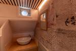 Wastafel onder een patrijspoort in een hut van de Avontuur