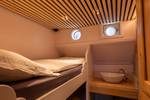 Hut met stapelbed en wastafel op de Avontuur