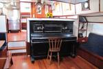 Piano in het dagverblijf van tjalk Aagtje