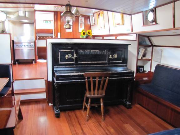 Piano in het dagverblijf van tjalk Aagtje
