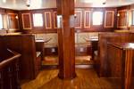 Houten zitbanken en tafels in de salon van de Abel Tasman