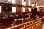Houten bar met glazen en flessen aan boord van de Abel Tasman