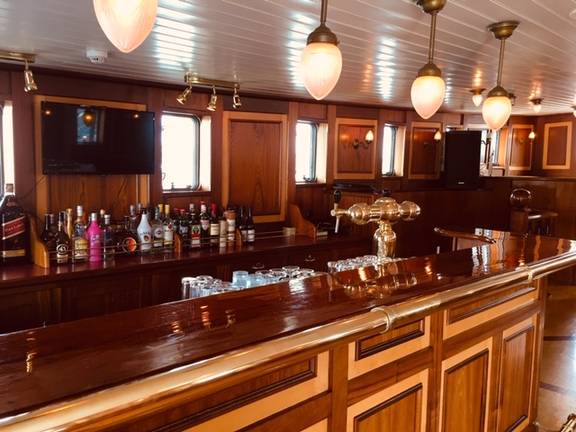 Houten bar met glazen en flessen aan boord van de Abel Tasman
