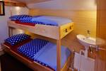 Houten stapelbed en wastafel in een hut van de Albatros