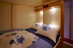 Tweepersoonsbedstee met blauw-wit beddengoed op de Albatros