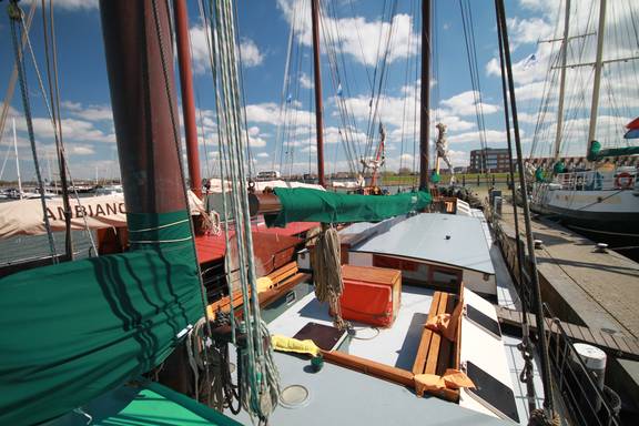 Uitzicht over het dek en de zitkuip van de Allure in de haven