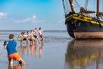 Scholieren poseren naast de Ambiance op het drooggevallen Wad