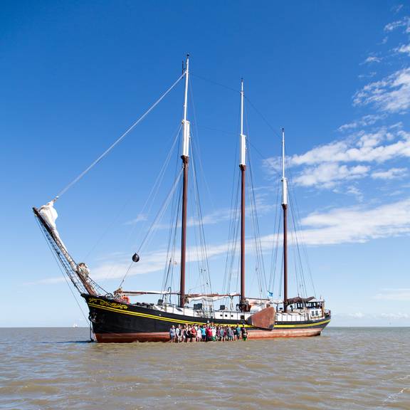 Groep naast de Ambiance op het drooggevallen Wad
