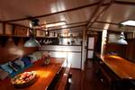 Salon van de Anna Trijntje met houten tafels en blauwe zitbanken