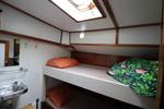 Bed en wastafel onder het dakluik van een hut op de Anna Trijntje