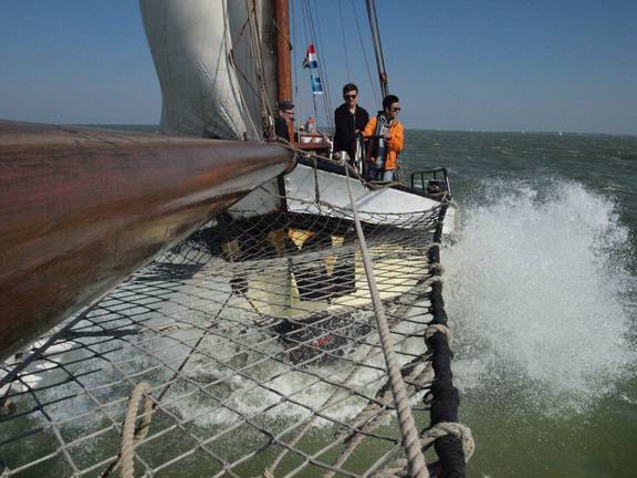 Gasten bij de boeg van de Anna Trijntje met opspattend boegwater