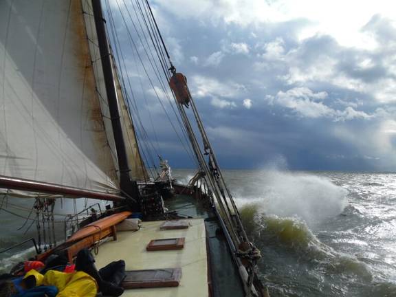 Anna Trijntje zeilt door de golven onder een bewolkte hemel