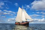 Klipper Anna met witte zeilen onder een blauwe lucht