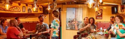 Gezelschap in de salon met bar aan boord van de Anna
