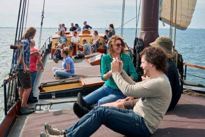 Gasten zitten samen aan dek van klipper Anna