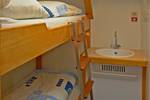 Houten stapelbed en wastafel in een hut van de Avanti