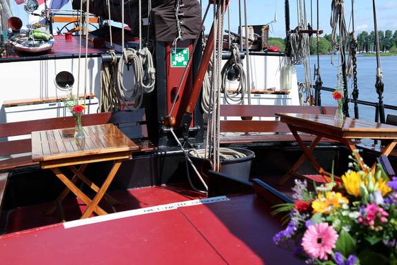 Zitkuip met houten tafels en bloemen op de Avondrood