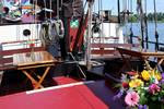 Zitkuip met houten tafels en bloemen op de Avondrood