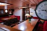 Eettafels en wandklok in de salon van de Avondrood
