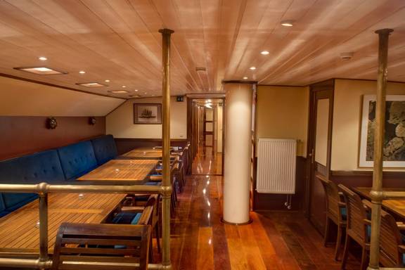 Houten salon van de Summertime met eettafels en zitbanken