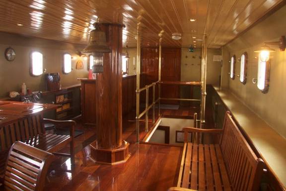 Houten salon van de Summertime met eettafels en zitbanken