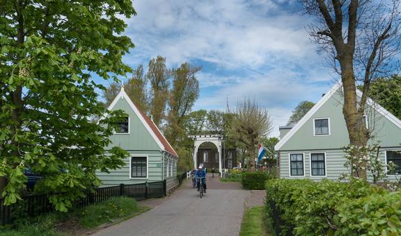Fietser tussen groene houten huizen in een dorp