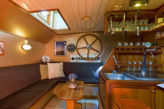 Houten bar en zithoek met scheepsdecoratie op de Boekanier