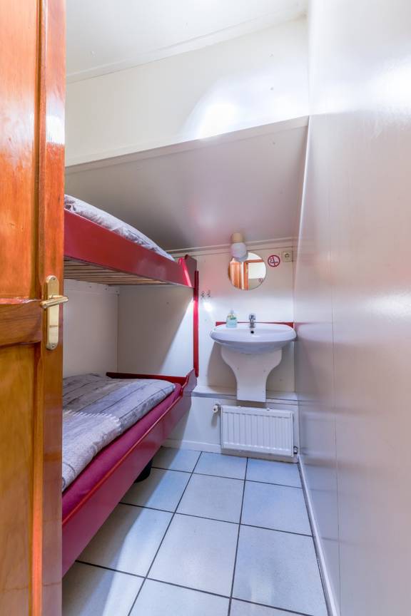 Tweepersoonshut met stapelbed en wastafel op de Boekanier