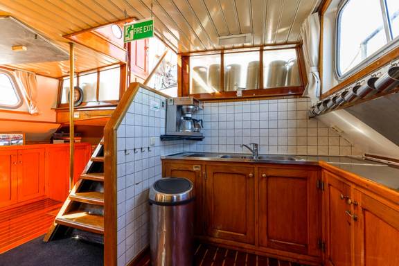 Kombuis met houten kasten naast de trap op de Boekanier