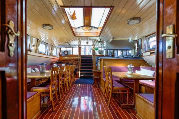 Salon van de Boekanier met houten tafels en stoelen
