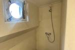 Douche met patrijspoort aan boord van de Boekanier