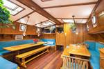 Houten eettafels en blauwe zitbanken in de salon van de Bonnefooi