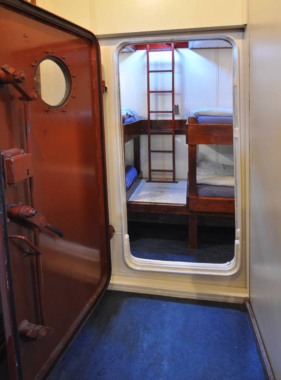 Doorkijk door een scheepsdeur naar een vierpersoonshut van de Chateauroux