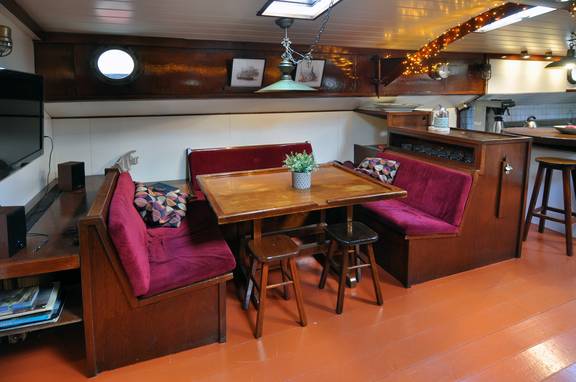 Zithoek met houten tafel en rode banken in de Chateauroux