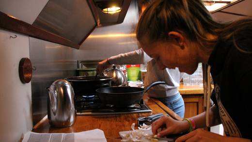Samen koken in de kombuis: knoflook snijden en in de pan roeren