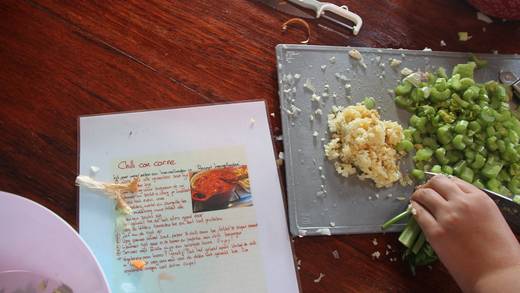 Groenten snijden naast een recept voor chili con carne