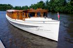Salonboot Dame van Amstel met houten kajuit op het water