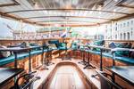 Lichte salon van de Dame van Amstel met houten tafels en turquoise zitbanken