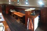 Salon van de Dankbaarheid met houten tafels en zitbanken