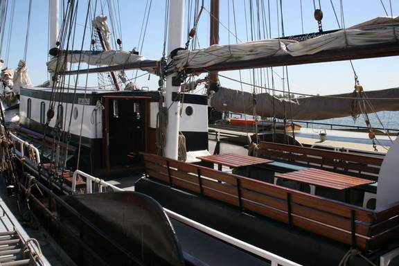 Houten banken en tafels in de zitkuip van de Vrijheid