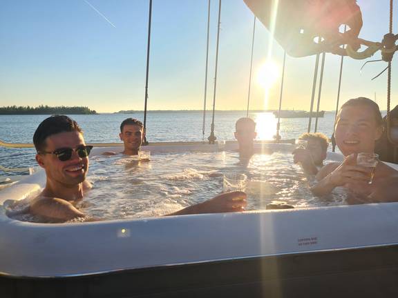 Gezelschap in de jacuzzi van De Hester bij laagstaande zon