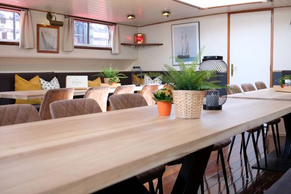 Lange eettafels met planten in de salon van De Hester