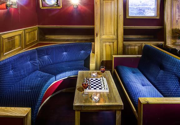 Zithoek met blauwe banken en een schaakspel op de Elizabeth