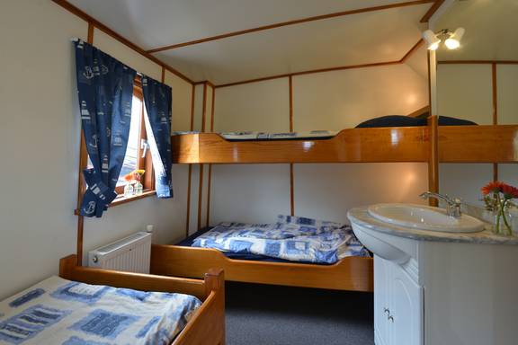 Hut met houten stapelbedden en wastafel op de Elizabeth