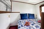 Tweepersoonsbed met blauwe kussens in een hut van de Elizabeth