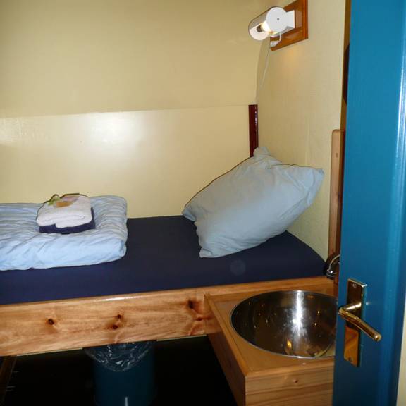 Hut met bed en wastafel op de Gouwzee